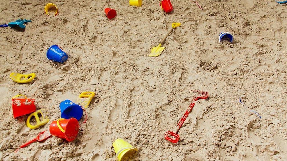 Childrens toys lying scattered in the sand 