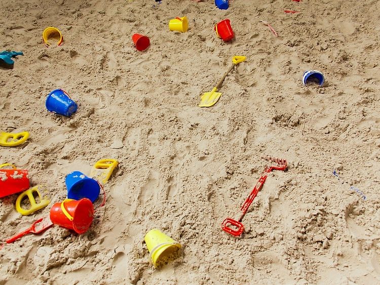  Childrens toys lying scattered in the sand 
