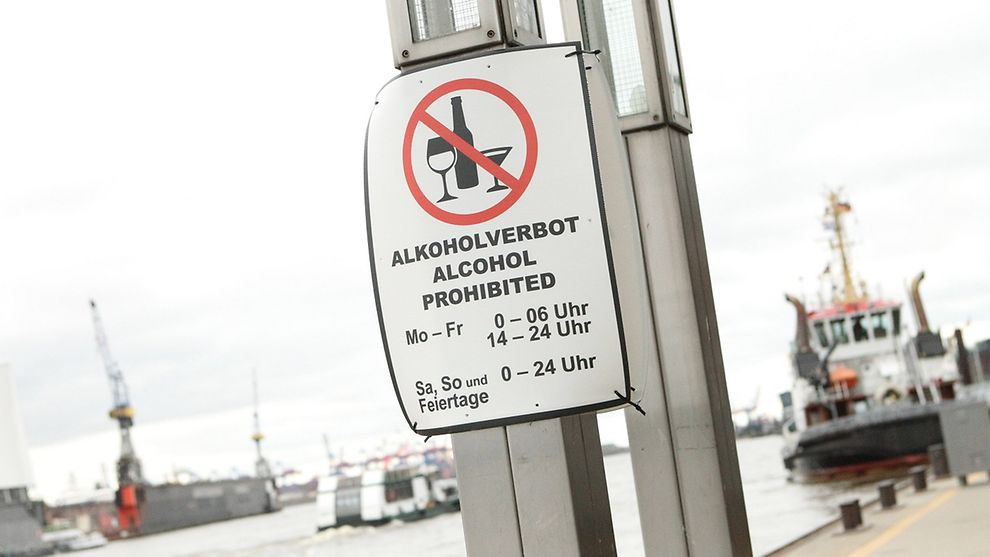 A sign hangs on a pole at Hamburg harbour, indicating that alcohol is prohibited in this area at certain times