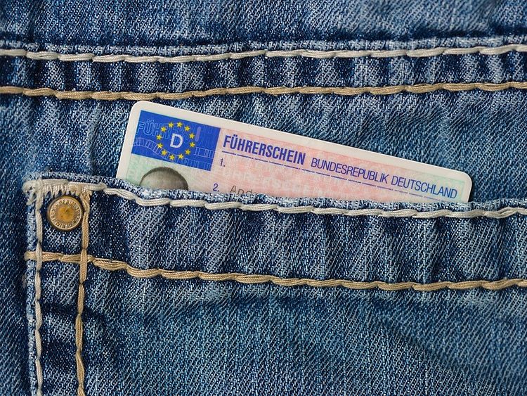 A German driver's licence card sticking out of the back pocket of a blue jeans. The blue flag of Europe and the words "Führerschein Bundesrepublik Deutschland" are visible.