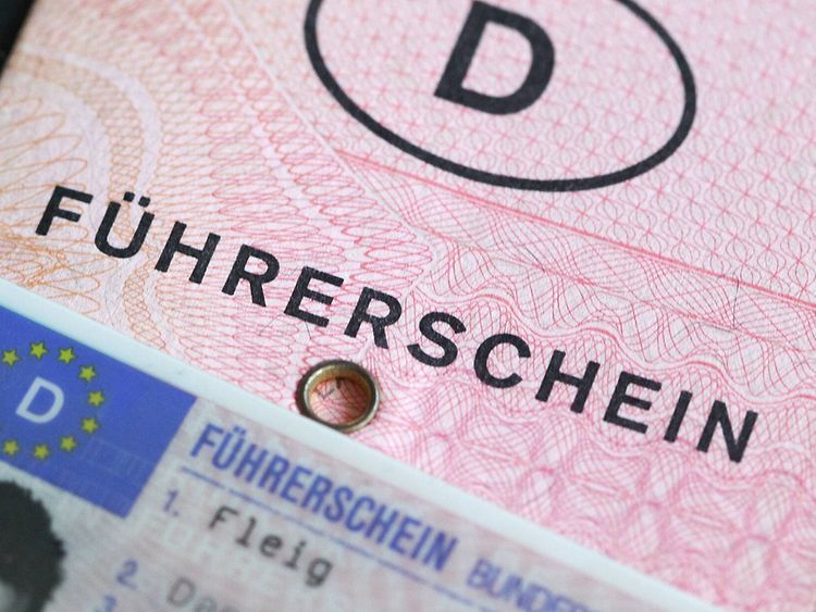 The formerly official German driver's licence made from light red paper. In the foreground