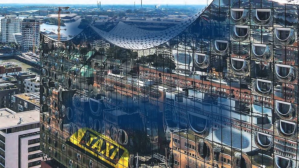  Reflection of a taxi on the facade of the Elbphilharmonie in Hamburg