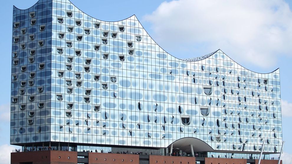 Total view of the Elbphilharmonie concert hall on top of a red-brick warehouse