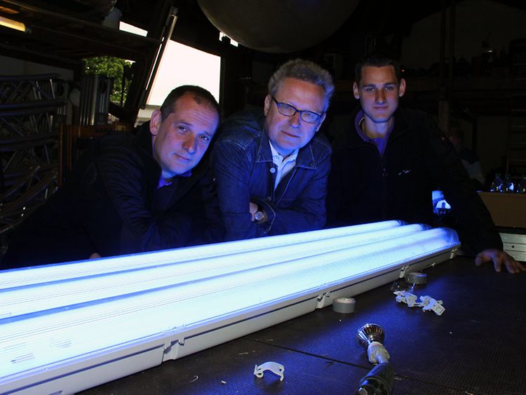  Michael Batz (centre) with team members in front of fluorescent tubes