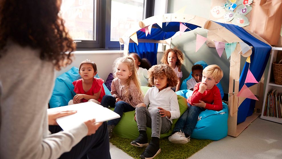  A kindergarten teacher reading a book to a group of children