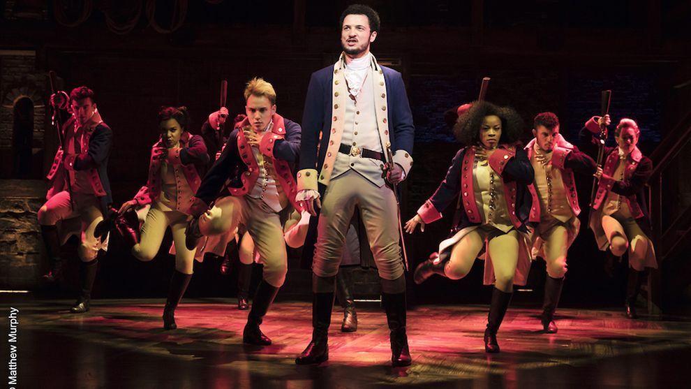  Scene from Hamilton: Alexander Hamilton and other cast members stand guard in uniform.