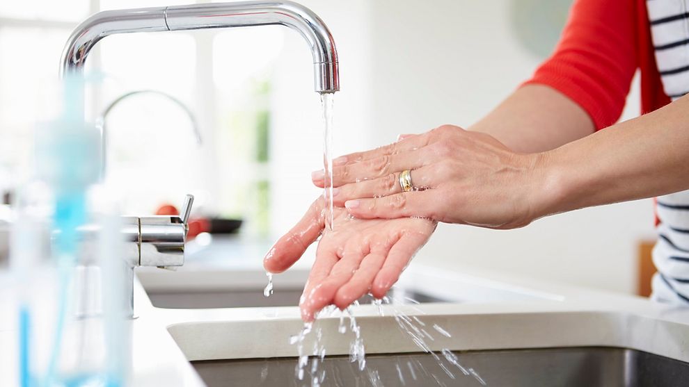 Person washing their hands in a modern sink