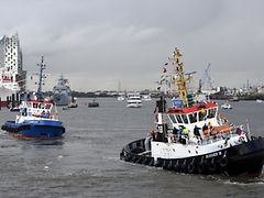  Two out of four tugboats on the Elbe river with Elbphilharmonie concert hall in background