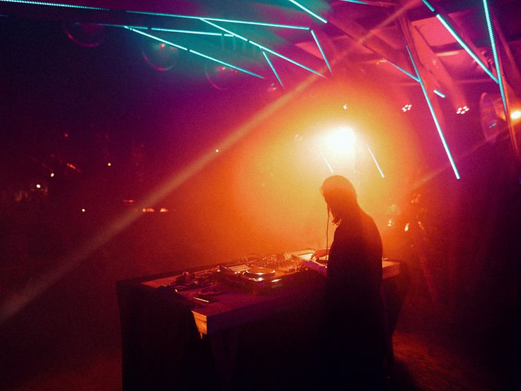  A DJ spins on stage amidst colourful lights