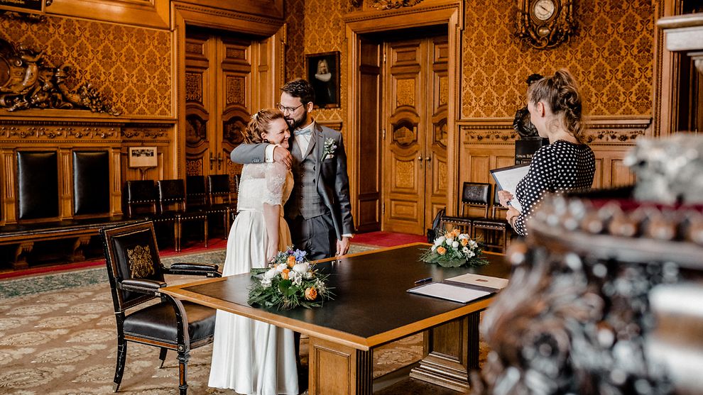 A bridal couple in front of a civil clerk's desk inside the Kaisersaal of the City Hall in Hamburg
